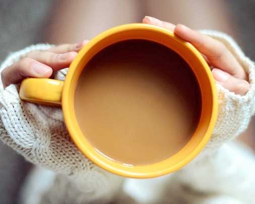 Girl holding orange cup of coffee