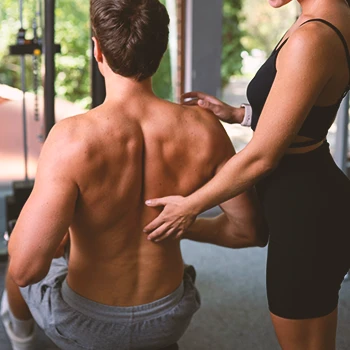 A coach teaching someone to lift properly