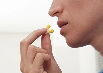 Taking two supplement pills