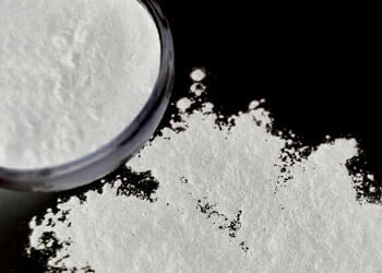 Caffeine Anhydrous on floor and on a container