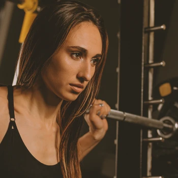 A woman using a power rack in the gym