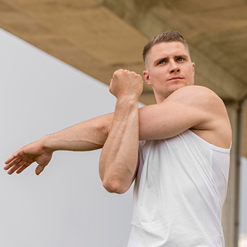 A young man doing a morning stretch after using Testogen supplement