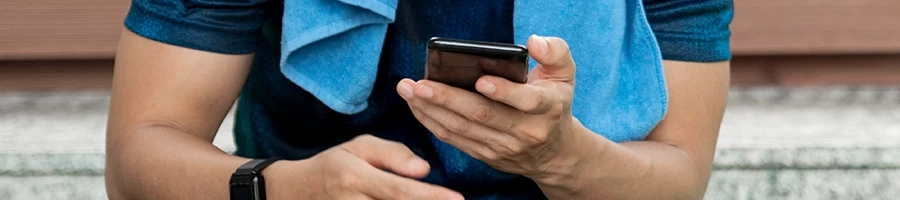 A man browsing his phone to buy smith machine online