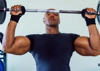 A man doing pull ups while wearing gloves