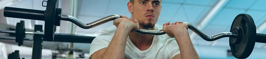 A man lifting barbell to grow forearms