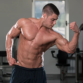 A perfectly fit guy flexing his muscle in the gym