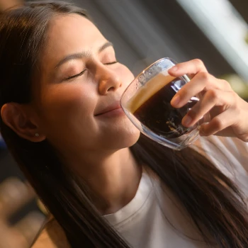 A woman holding a caffeine drink