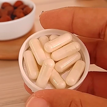 a person holding caffeine pills in a cap