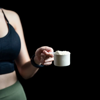 woman showing a protein powder scooper